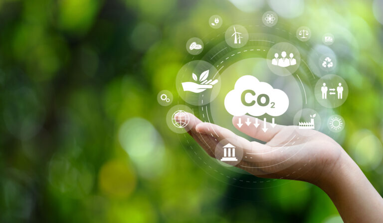 CO2 emission reduction concept in hand with environmental icons, global warming, sustainable development, connectivity and renewable energy green business background